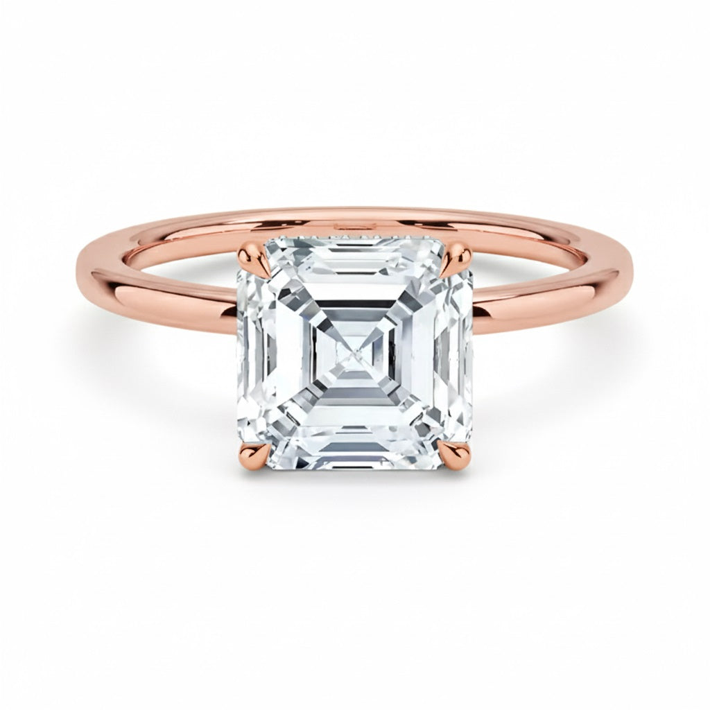 Asher  cut Moissanite lab grown diamond engagement ring round shank with a four claw setting, on a gold band, against a white background.Moissanite engagement ring cape town south africa grand diamonds ralph jacobs jeulia