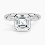 alt="An Asscher-cut Moissanite engagement ring with a bezel setting, displayed on a gold band, against a white background.Moissanite engagement ring cape town south africa grand diamonds ralph jacobs jeulia "