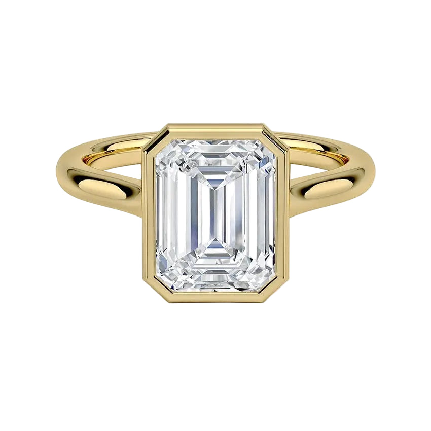 alt="An Emarald cut Moissanite engagement ring round shank with a bezel setting, on a gold band, against a white background.Moissanite engagement ring cape town south africa grand diamonds ralph jacobs jeulia "