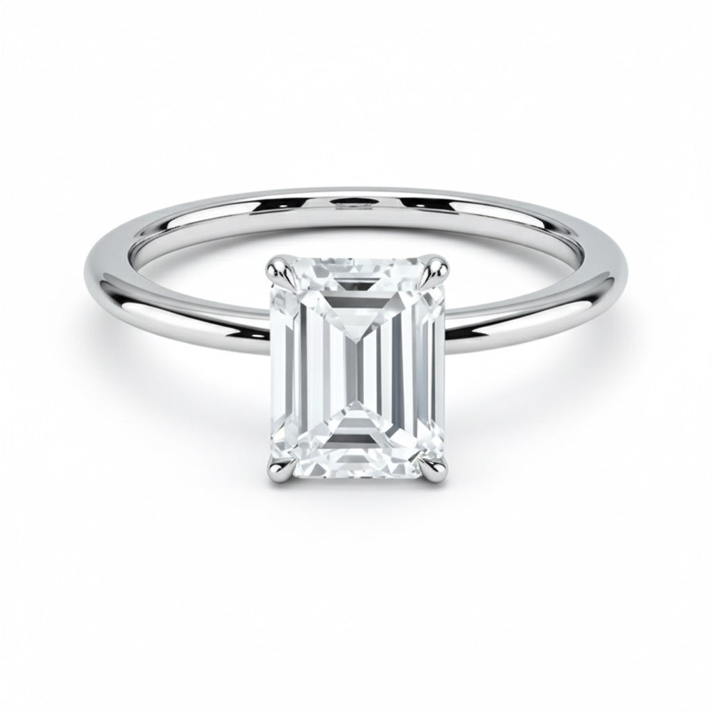 Emerald  cut Moissanite lab grown diamond engagement ring round shank with a four claw setting, on a gold band, against a white background.Moissanite engagement ring cape town south africa grand diamonds ralph jacobs jeulia