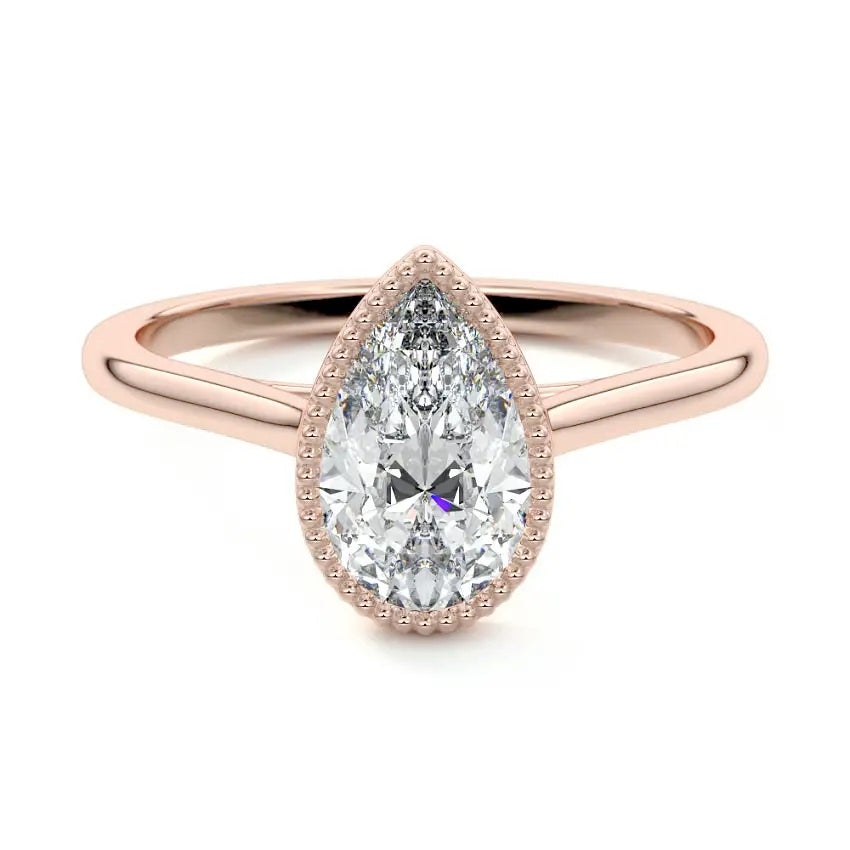 Pear shape Moissanite lab grown diamond engagement ring round shank with a bezel setting, on a gold band, against a white background.Moissanite engagement ring cape town south africa grand diamonds ralph jacobs jeulia