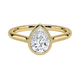 Pear shape Moissanite lab grown diamond engagement ring round shank with a bezel setting, on a gold band, against a white background.Moissanite engagement ring cape town south africa grand diamonds ralph jacobs jeulia