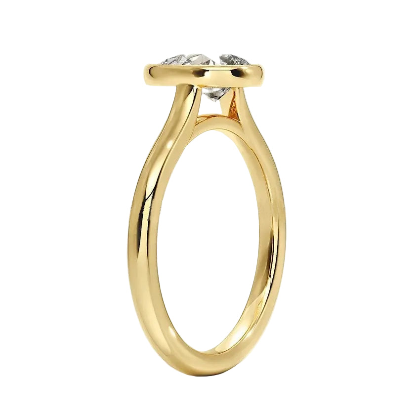 Pear shape Moissanite lab grown diamond engagement ring round shank with a bezel setting, on a gold band, against a white background.Moissanite engagement ring cape town south africa grand diamonds ralph jacobs jeulia