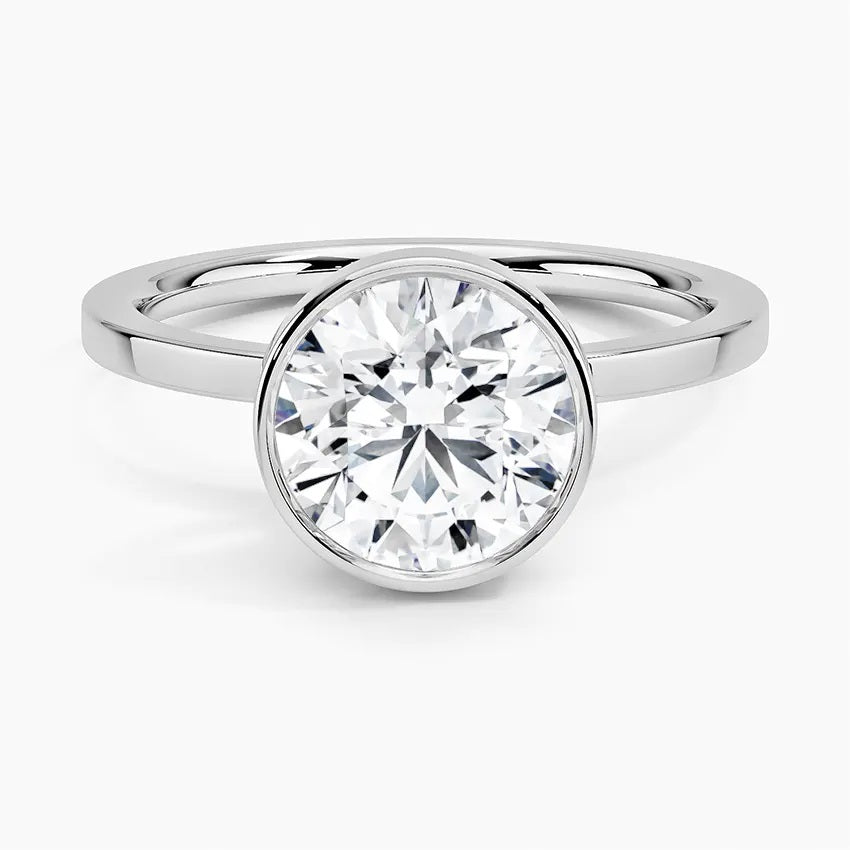 Round cut Moissanite lab grown diamond engagement ring round shank with a bezel setting, on a gold band, against a white background.Moissanite engagement ring cape town south africa grand diamonds ralph jacobs jeulia
