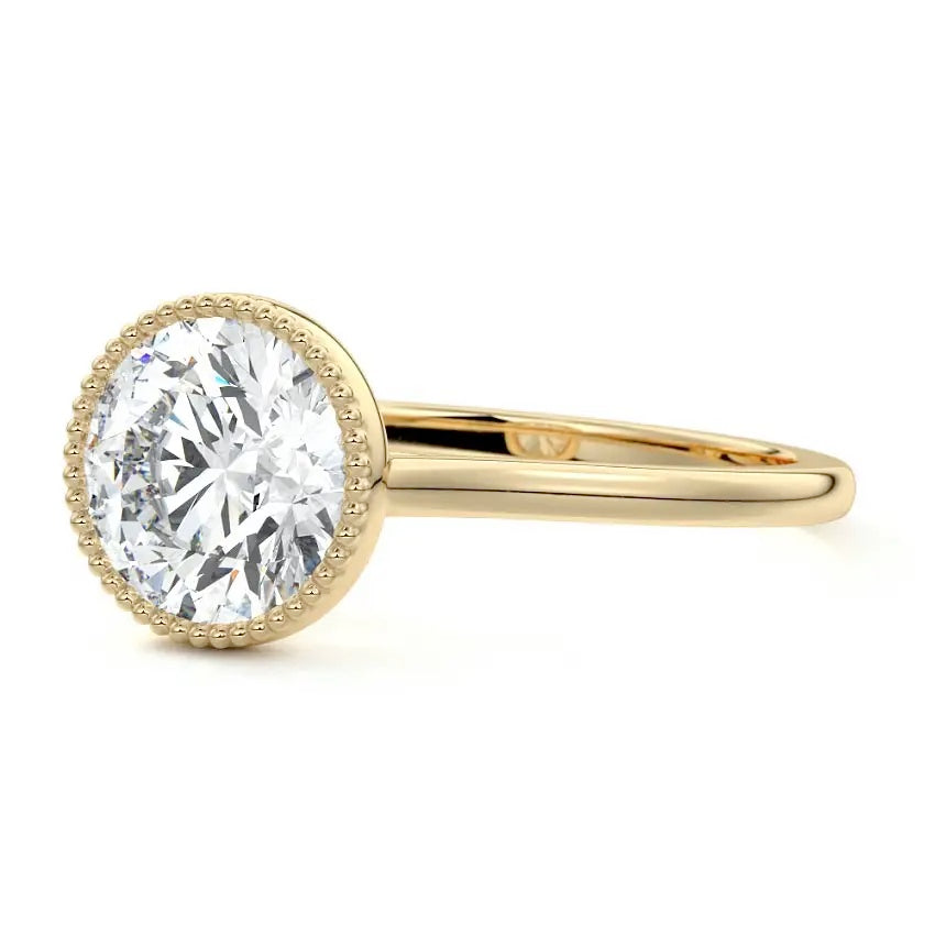 Round cut Moissanite lab grown diamond engagement ring round shank with a bezel setting, on a gold band, against a white background.Moissanite engagement ring cape town south africa grand diamonds ralph jacobs jeulia