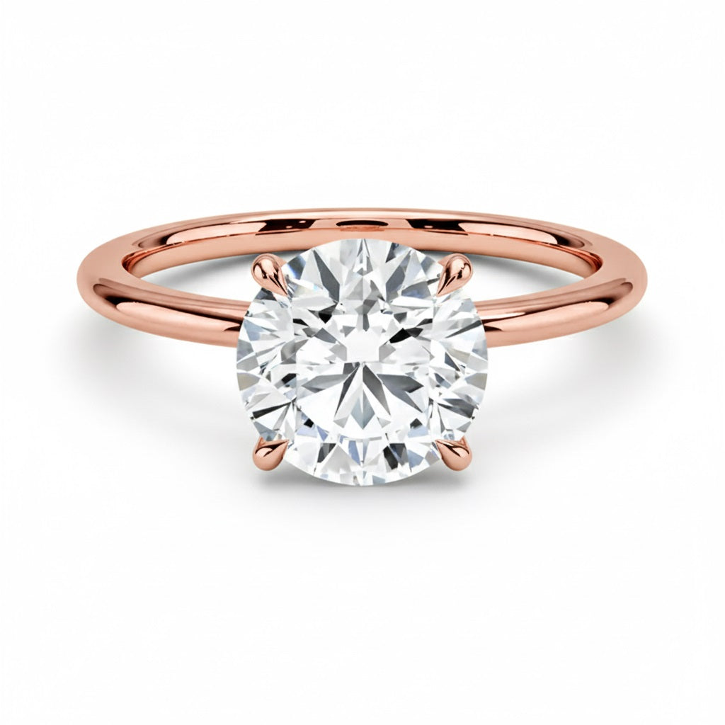 Engagement ring round cut Moissanite lab grown diamond engagement ring round shank with a four claw setting, on a gold band, against a white background.Moissanite engagement ring cape town south africa grand diamonds ralph jacobs jeulia