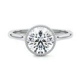 Round cut Moissanite lab grown diamond engagement ring round shank with a bezel setting, on a gold band, against a white background.Moissanite engagement ring cape town south africa grand diamonds ralph jacobs jeulia