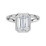 alt="An Emarald cut Moissanite engagement ring round shank with a bezel setting, on a gold band, against a white background.Moissanite engagement ring cape town south africa grand diamonds ralph jacobs jeulia