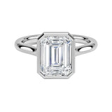 alt="An Emarald cut Moissanite engagement ring round shank with a bezel setting, on a gold band, against a white background.Moissanite engagement ring cape town south africa grand diamonds ralph jacobs jeulia