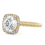 alt="Round-cut moissanite engagement ring with a halo and a twisted pavé band by ApolloGem"
