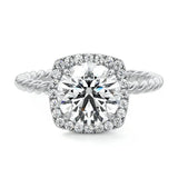 alt="Round-cut moissanite engagement ring with a halo and a twisted pavé band by ApolloGem"
