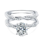 alt="Elegant oval cut engagement ring set with a twisted wedding band by ApolloGem"