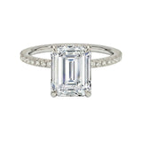 Diamond ring with emerald-cut center stone on a white background