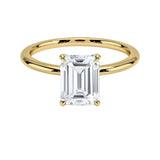 Emerald  cut Moissanite lab grown diamond engagement ring round shank with a four claw setting, on a gold band, against a white background.Moissanite engagement ring cape town south africa grand diamonds ralph jacobs jeulia 