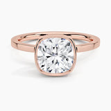 alt="An Cushion cut Moissanite engagement ring with a bezel setting, displayed on a gold band, against a white background.Moissanite engagement ring cape town south africa grand diamonds ralph jacobs jeulia "