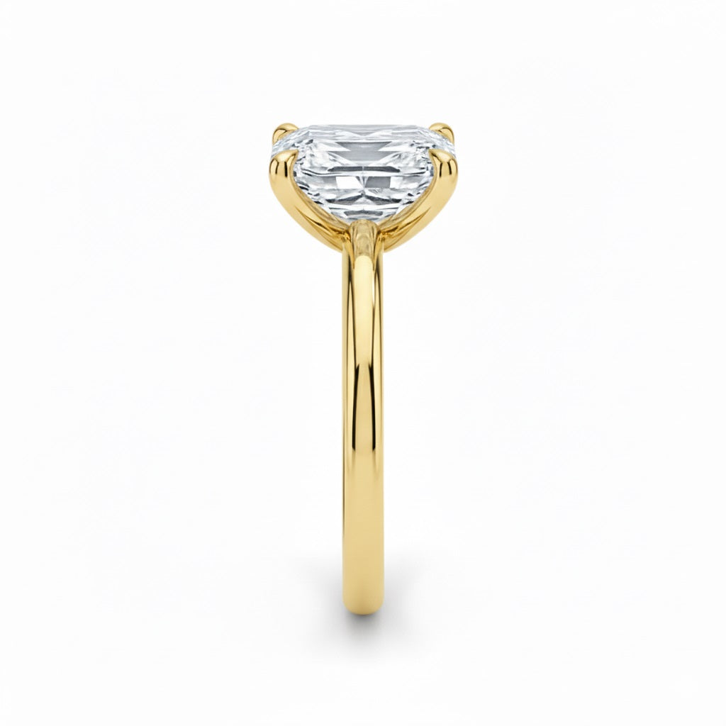 Asher  cut Moissanite lab grown diamond engagement ring round shank with a four claw setting, on a gold band, against a white background.Moissanite engagement ring cape town south africa grand diamonds ralph jacobs jeulia 