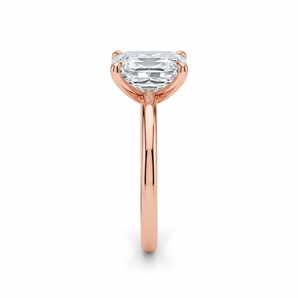 Asher  cut Moissanite lab grown diamond engagement ring round shank with a four claw setting, on a gold band, against a white background.Moissanite engagement ring cape town south africa grand diamonds ralph jacobs jeulia 