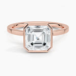 alt="An Asscher-cut Moissanite engagement ring with a bezel setting, displayed on a gold band, against a white background.Moissanite engagement ring cape town south africa grand diamonds ralph jacobs jeulia "