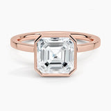 alt="An Asscher-cut Moissanite engagement ring with a bezel setting, displayed on a gold band, against a white background.Moissanite engagement ring cape town south africa grand diamonds ralph jacobs jeulia "