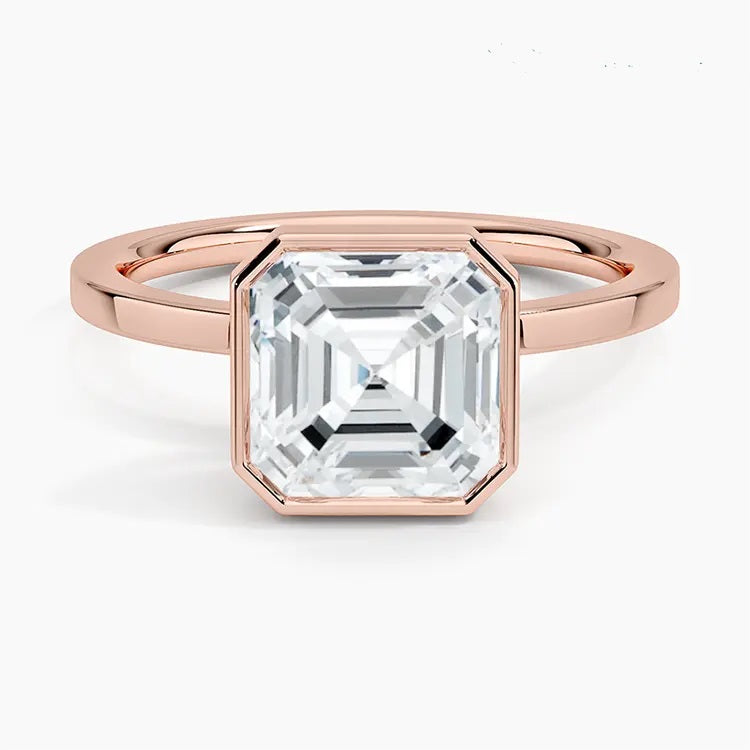 alt="An Asscher-cut Moissanite engagement ring with a bezel setting, displayed on a gold band, against a white background.Moissanite engagement ring cape town south africa grand diamonds ralph jacobs jeulia "