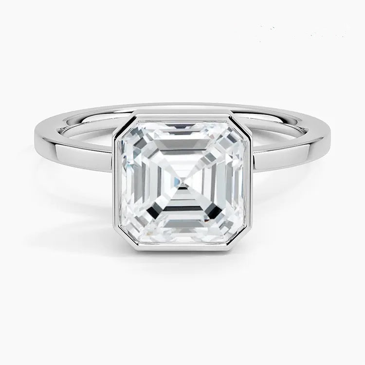 alt="An Asscher-cut Moissanite engagement ring with a bezel setting, displayed on a gold band, against a white background.Moissanite engagement ring cape town south africa grand diamonds ralph jacobs jeulia "