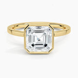 alt="An Asscher-cut Moissanite engagement ring with a bezel setting, displayed on a gold band, against a white background.Moissanite engagement ring cape town south africa grand diamonds ralph jacobs jeulia "