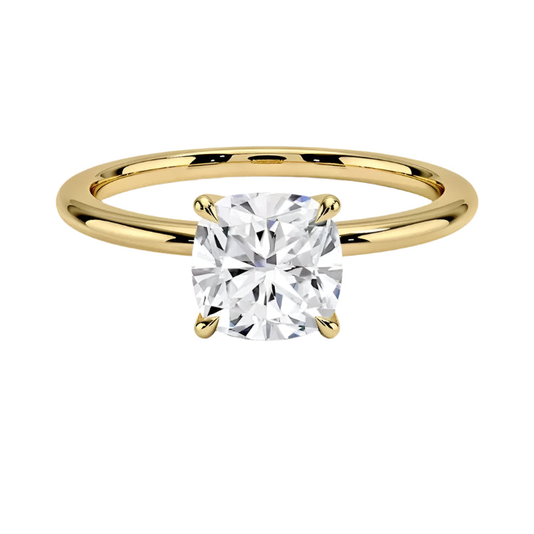 Cushion cut Moissanite lab grown diamond engagement ring round shank with a four claw setting, on a gold band, against a white background.Moissanite engagement ring cape town south africa grand diamonds ralph jacobs jeulia 
