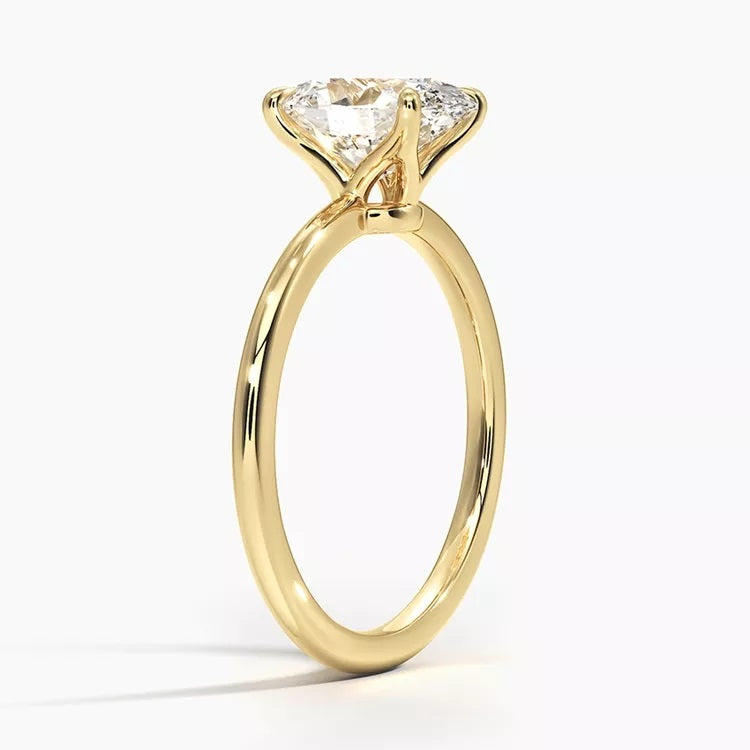 Cushion cut Moissanite lab grown diamond engagement ring round shank with a four claw setting, on a gold band, against a white background.Moissanite engagement ring cape town south africa grand diamonds ralph jacobs jeulia 