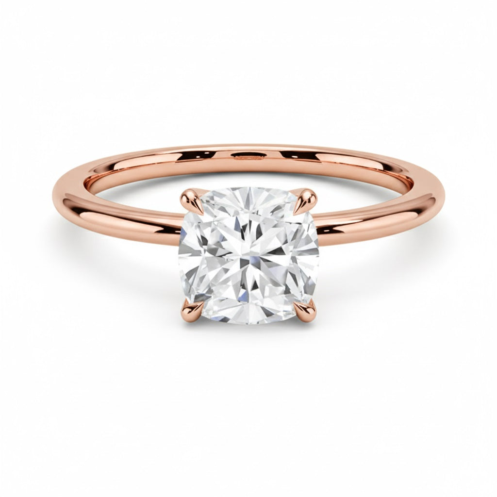 Cushion cut Moissanite lab grown diamond engagement ring round shank with a four claw setting, on a gold band, against a white background.Moissanite engagement ring cape town south africa grand diamonds ralph jacobs jeulia 