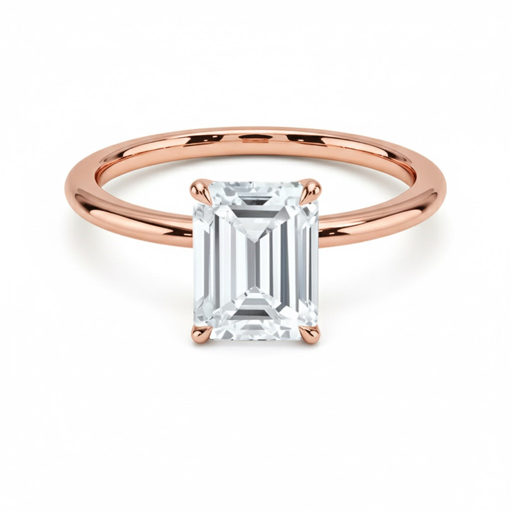 Emerald  cut Moissanite lab grown diamond engagement ring round shank with a four claw setting, on a gold band, against a white background.Moissanite engagement ring cape town south africa grand diamonds ralph jacobs jeulia 