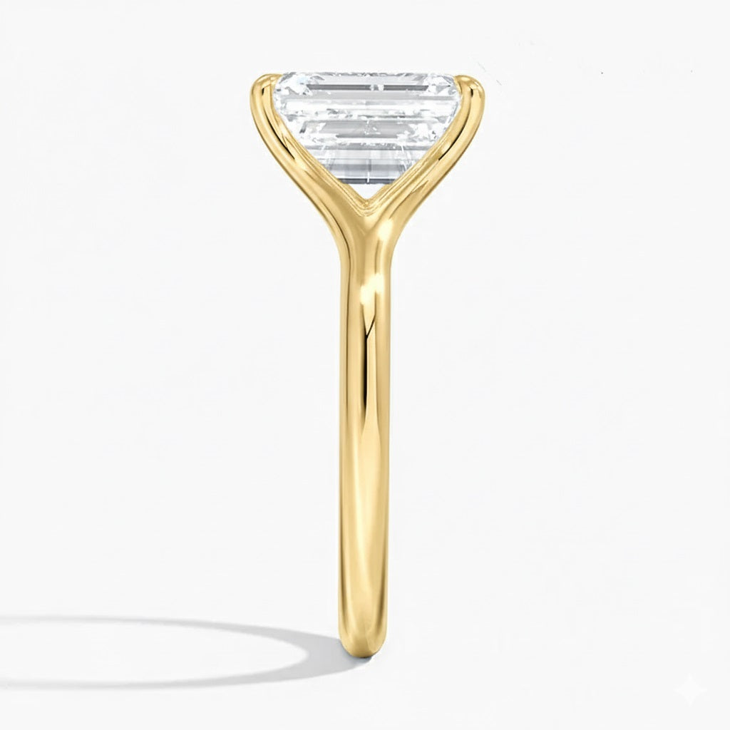 Emerald  cut Moissanite lab grown diamond engagement ring V-split band  with a four claw setting, on a gold band, against a white background.Moissanite engagement ring cape town south africa grand diamonds ralph jacobs jeulia  