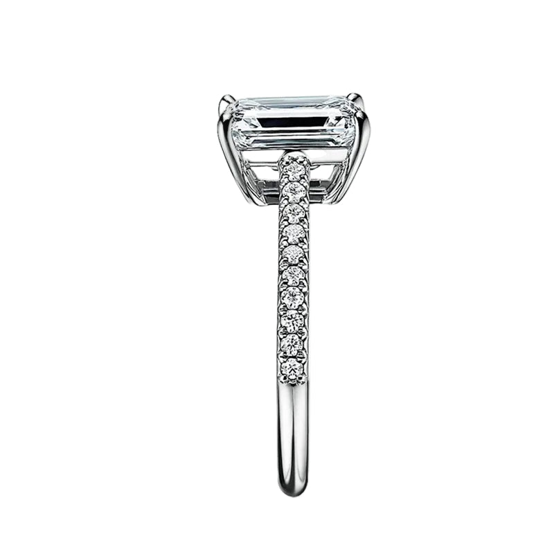 Emerald cut Moissanite lab grown diamond engagement ring pave set shank with a four claw setting, on a gold band, against a white background.Moissanite engagement ring cape town south africa grand diamonds ralph jacobs jeulia 