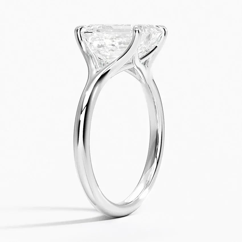 Emerald  cut Moissanite lab grown diamond engagement ring V-split band  with a four claw setting, on a gold band, against a white background.Moissanite engagement ring cape town south africa grand diamonds ralph jacobs jeulia  