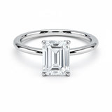 Emerald  cut Moissanite lab grown diamond engagement ring round shank with a four claw setting, on a gold band, against a white background.Moissanite engagement ring cape town south africa grand diamonds ralph jacobs jeulia 