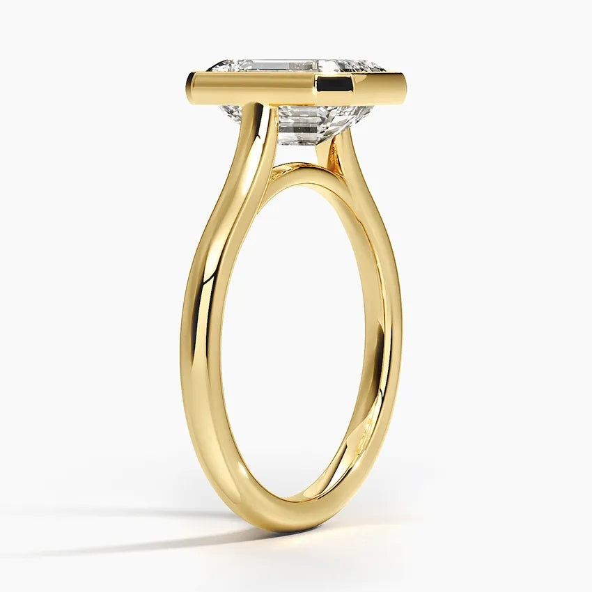 Princess cut Moissanite lab grown diamond engagement ring round shank with a bezel setting, on a gold band, against a white background.Moissanite engagement ring cape town south africa grand diamonds ralph jacobs jeulia 