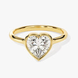  Heart shae Moissanite lab grown diamond engagement ring round shank with a bezel setting, on a gold band, against a white background.Moissanite engagement ring cape town south africa grand diamonds ralph jacobs jeulia 