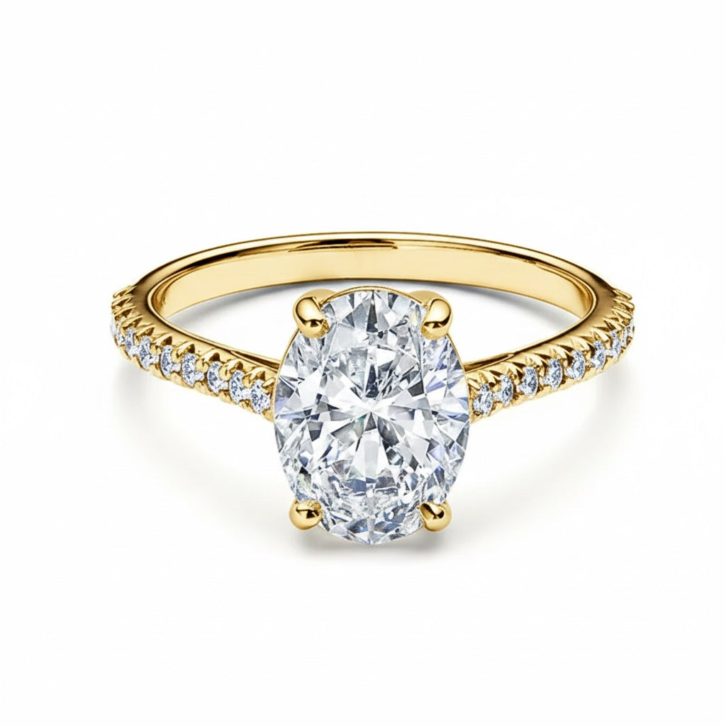 Oval cut Moissanite lab grown diamond engagement ring pave set shank with a four claw setting, on a gold band, against a white background.Moissanite engagement ring cape town south africa grand diamonds ralph jacobs jeulia 