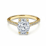 Oval cut Moissanite lab grown diamond engagement ring pave set shank with a four claw setting, on a gold band, against a white background.Moissanite engagement ring cape town south africa grand diamonds ralph jacobs jeulia 