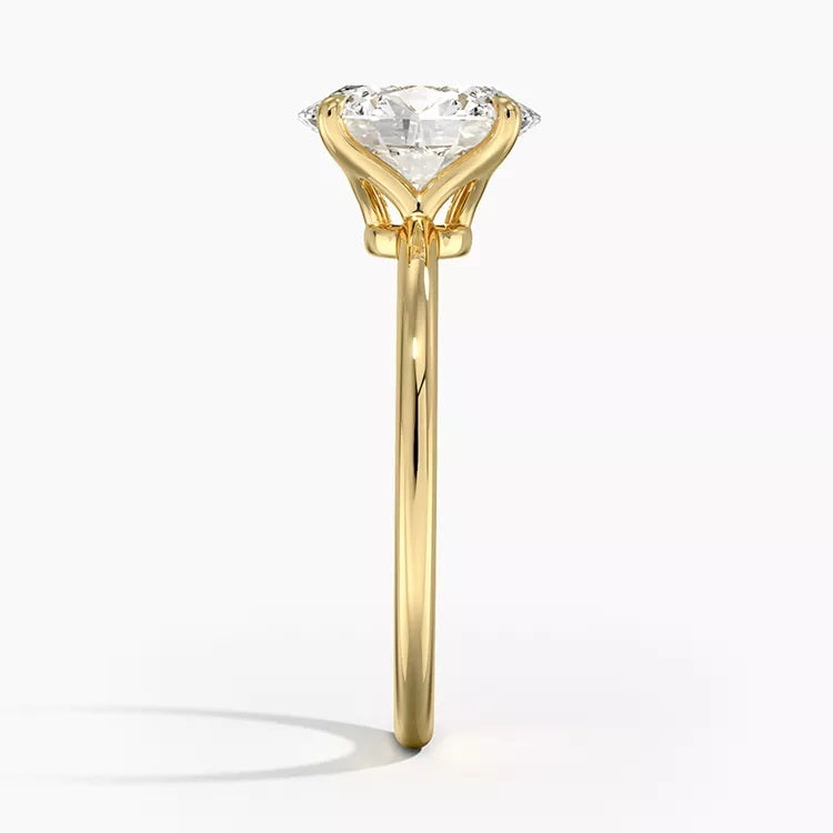 Oval cut Moissanite lab grown diamond engagement ring round shank with a four claw setting, on a gold band, against a white background.Moissanite engagement ring cape town south africa grand diamonds ralph jacobs jeuli
