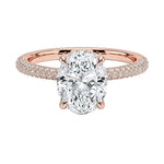 Oval cut Moissanite lab grown diamond engagement ring with three row micro pave set gold shank, hidden halo and encrusted claws against a white background.Moissanite engagement ring cape town south africa grand diamonds ralph jacobs jeulia 