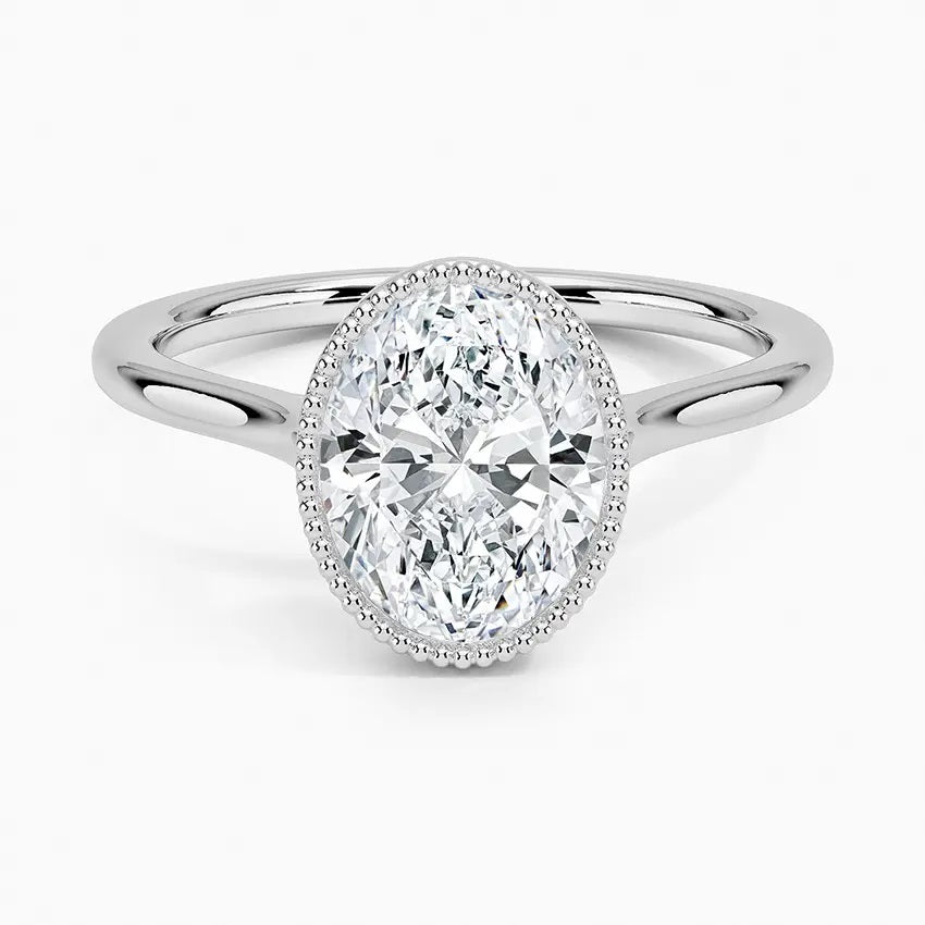 Oval shape Moissanite lab grown diamond engagement ring round shank with a bezel setting, on a gold band, against a white background.Moissanite engagement ring cape town south africa grand diamonds ralph jacobs jeulia 