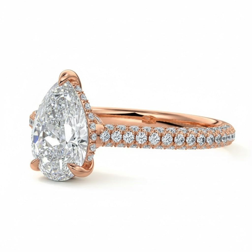 Pear cut Moissanite lab grown diamond engagement ring with three row micro pave set gold shank, hidden halo and moissanite encrusted claws against a white background.Moissanite engagement ring cape town south africa grand diamonds ralph jacobs jeulia 