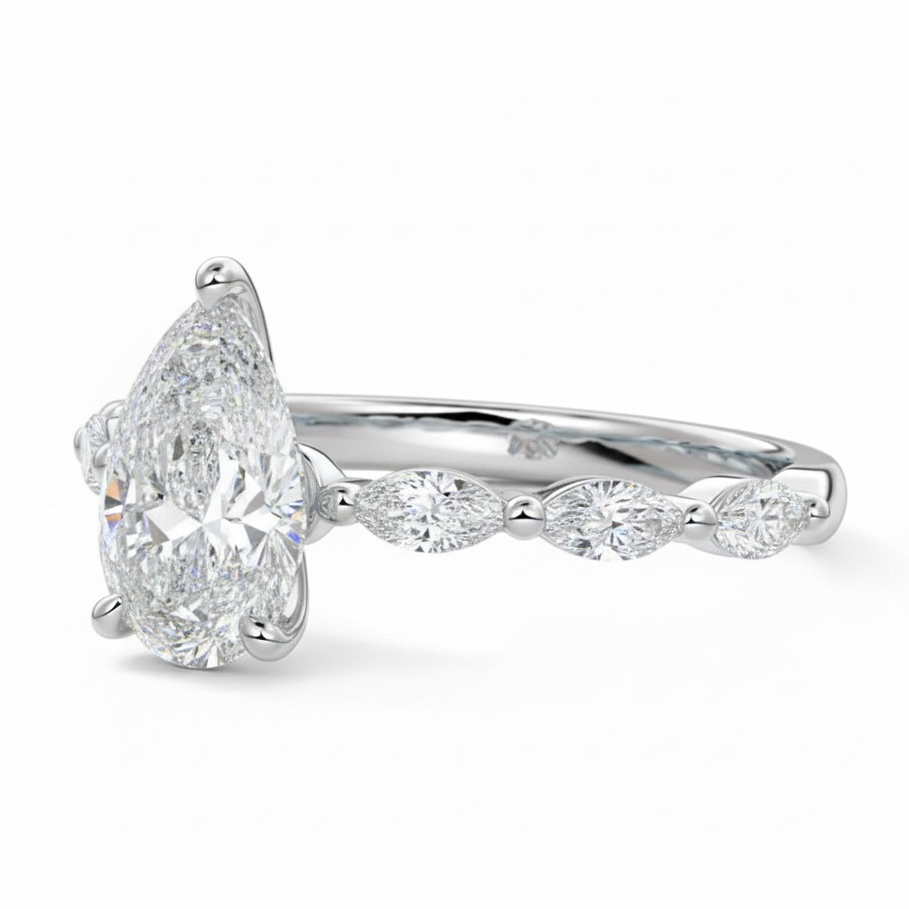 Pear cut Moissanite lab grown diamond engagement ring half eternity fancy set shank with classic three prong setting, on a gold band, against a white background.Moissanite engagement ring cape town south africa grand diamonds ralph jacobs jeulia 