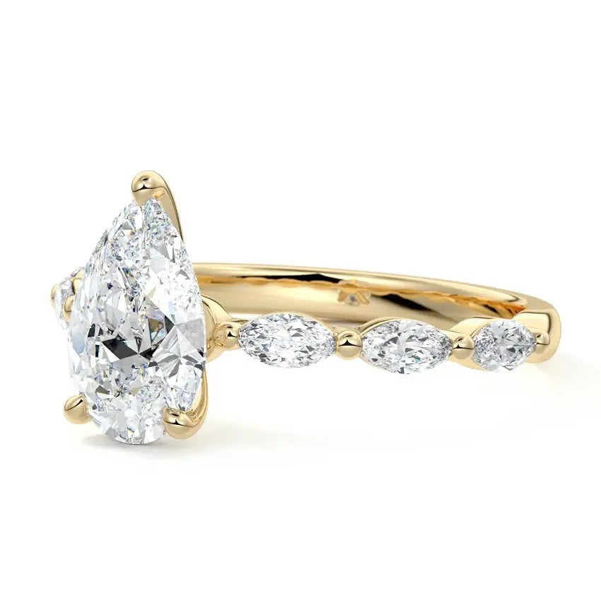 Pear cut Moissanite lab grown diamond engagement ring half eternity fancy set shank with classic three prong setting, on a gold band, against a white background.Moissanite engagement ring cape town south africa grand diamonds ralph jacobs jeulia 
