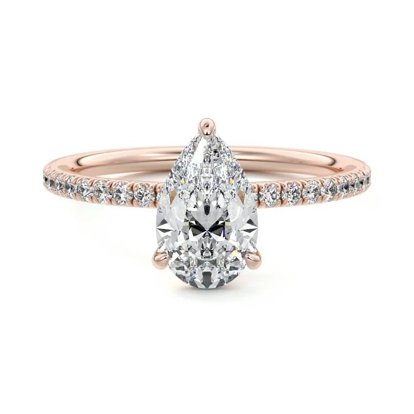 Pear cut Moissanite lab grown diamond engagement ring half eternity set shank with classic three prong setting, on a gold band, against a white background.Moissanite engagement ring cape town south africa grand diamonds ralph jacobs jeulia 