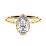 Pear shape Moissanite lab grown diamond engagement ring round shank with a bezel setting, on a gold band, against a white background.Moissanite engagement ring cape town south africa grand diamonds ralph jacobs jeulia 