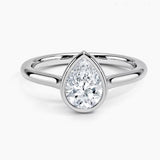 Pear shape Moissanite lab grown diamond engagement ring round shank with a bezel setting, on a gold band, against a white background.Moissanite engagement ring cape town south africa grand diamonds ralph jacobs jeulia 