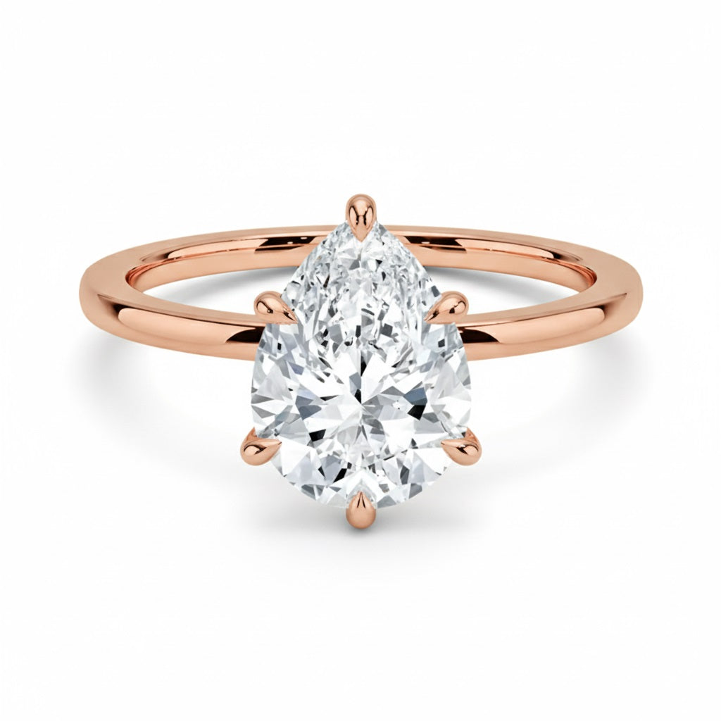 Pear cut Moissanite lab grown diamond engagement ring round shank with a six claw setting, on a gold band, against a white background.Moissanite engagement ring cape town south africa grand diamonds ralph jacobs jeuli