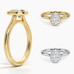Pear shape Moissanite lab grown diamond engagement ring round shank with a bezel setting, on a gold band, against a white background.Moissanite engagement ring cape town south africa grand diamonds ralph jacobs jeulia 