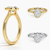 Pear shape Moissanite lab grown diamond engagement ring round shank with a bezel setting, on a gold band, against a white background.Moissanite engagement ring cape town south africa grand diamonds ralph jacobs jeulia 
